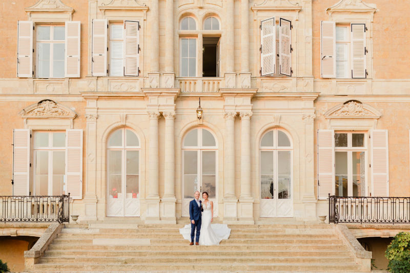 des mariés heureux devant le chateau pour leur shooting